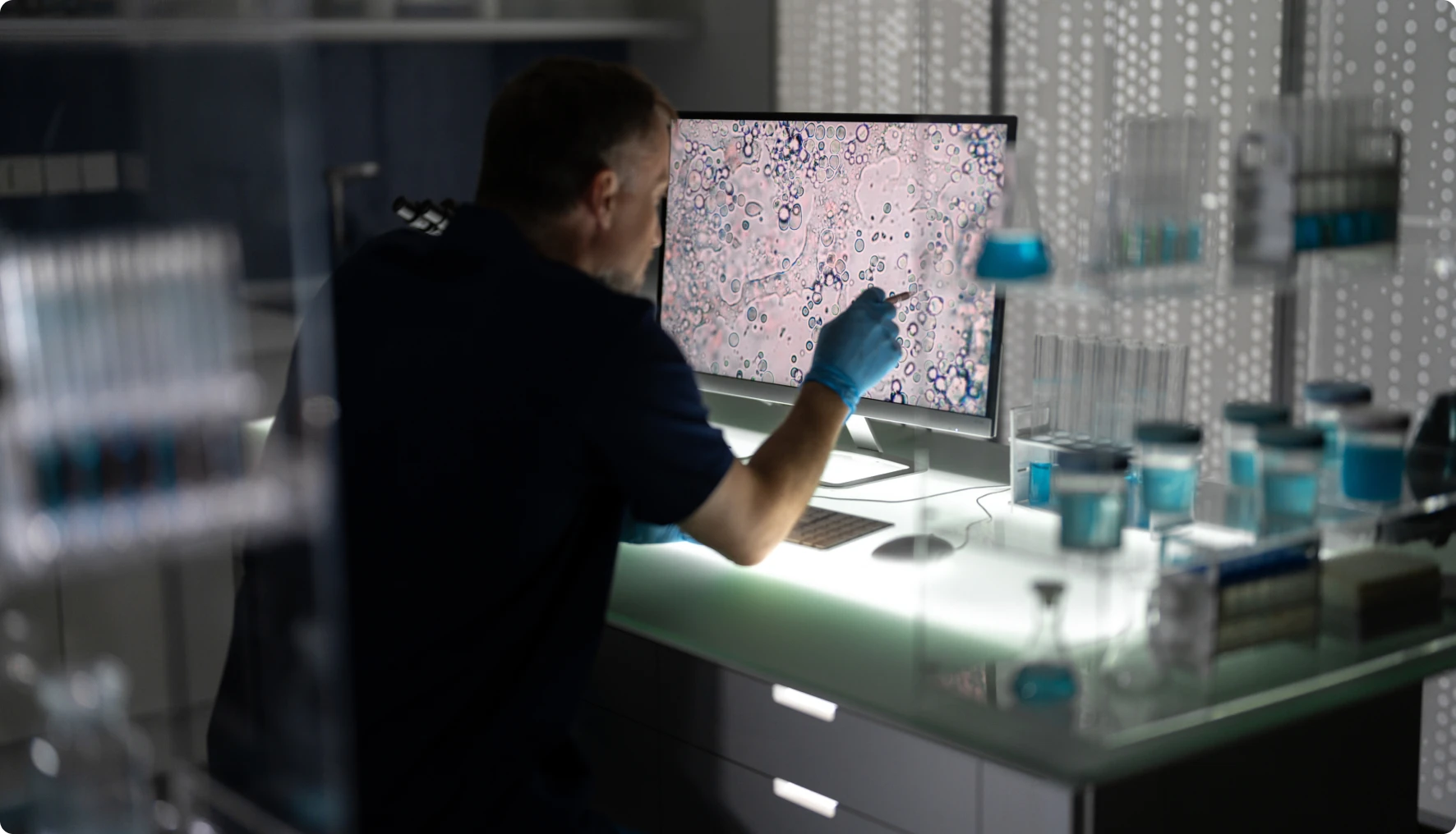 Scientist analyzing microscope image on computer screen.